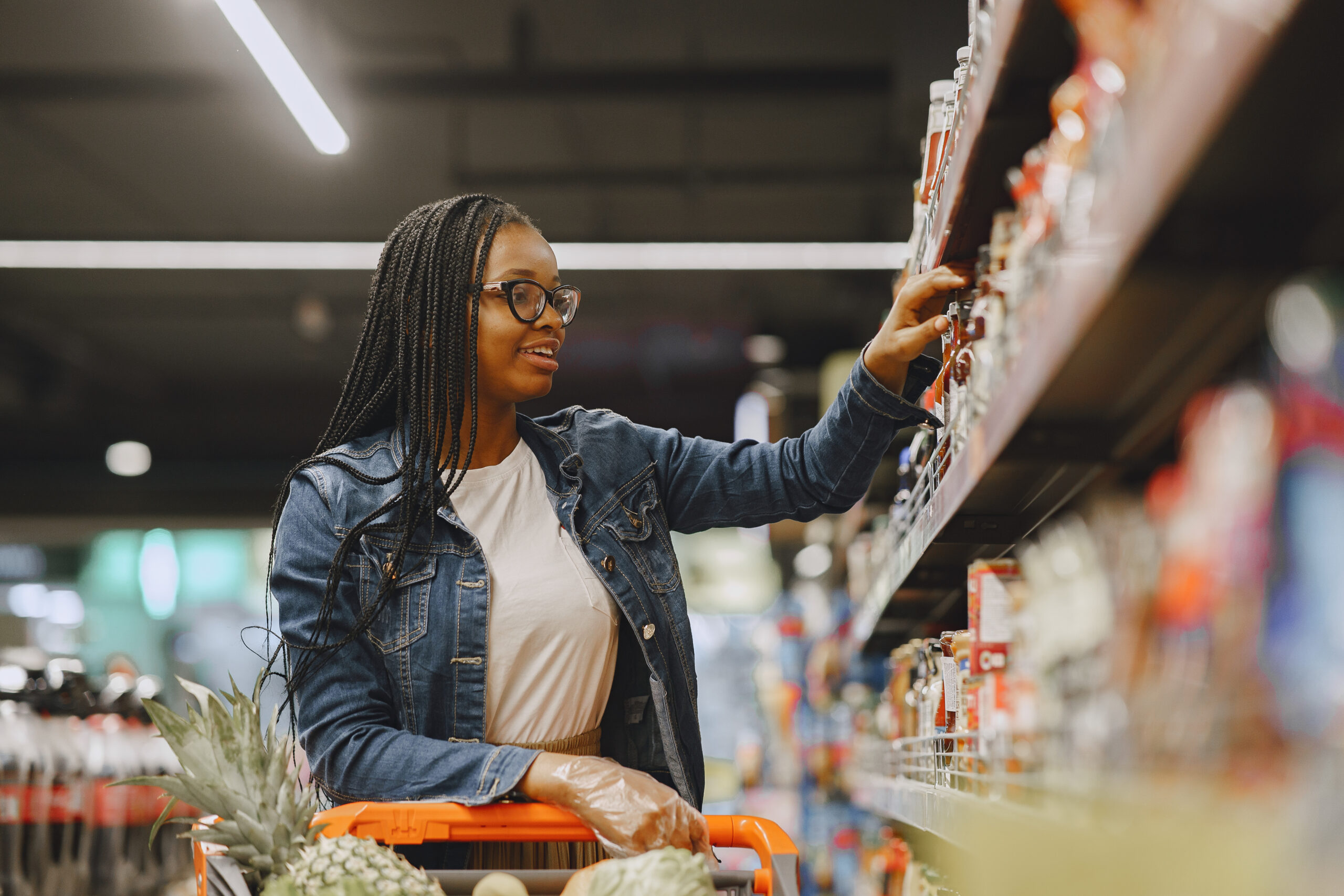 African woman with shopping cart. Girl in a supermarket.